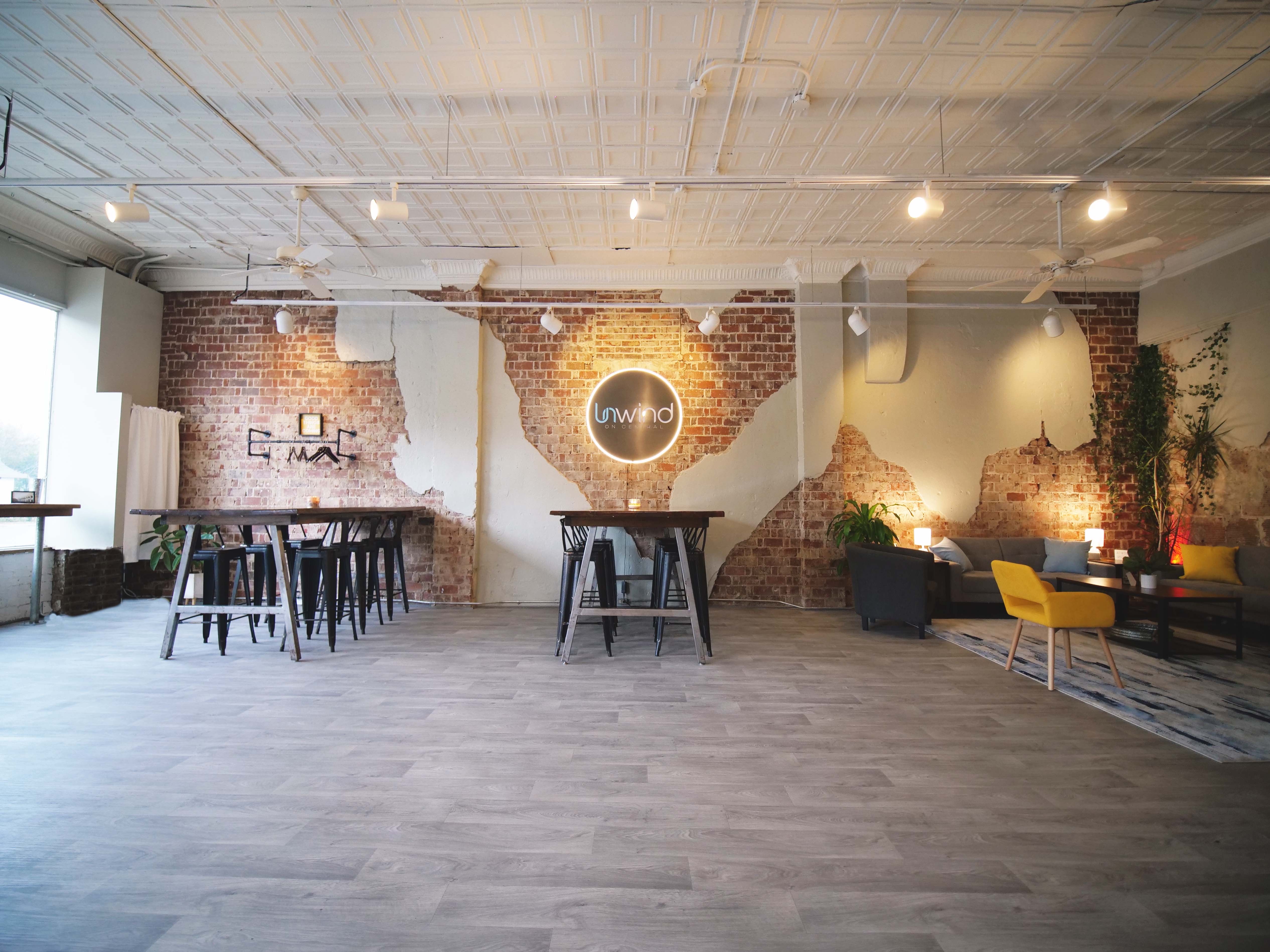 The main floor of Unwind on Central with exposed brick and rail lighting